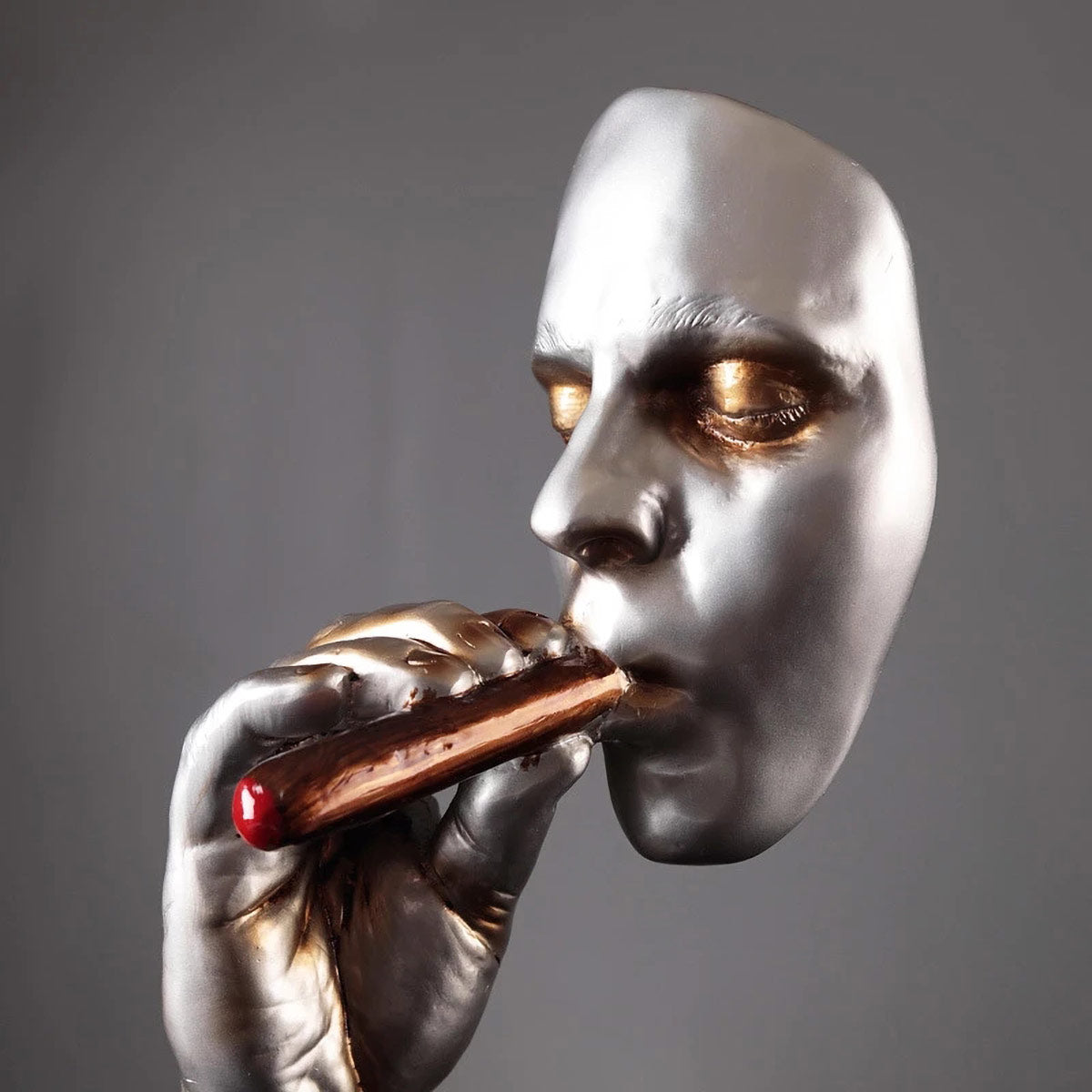 Elegant cigar smoker sculpture in silver with golden eyes - luxury man cave decor art piece close-up