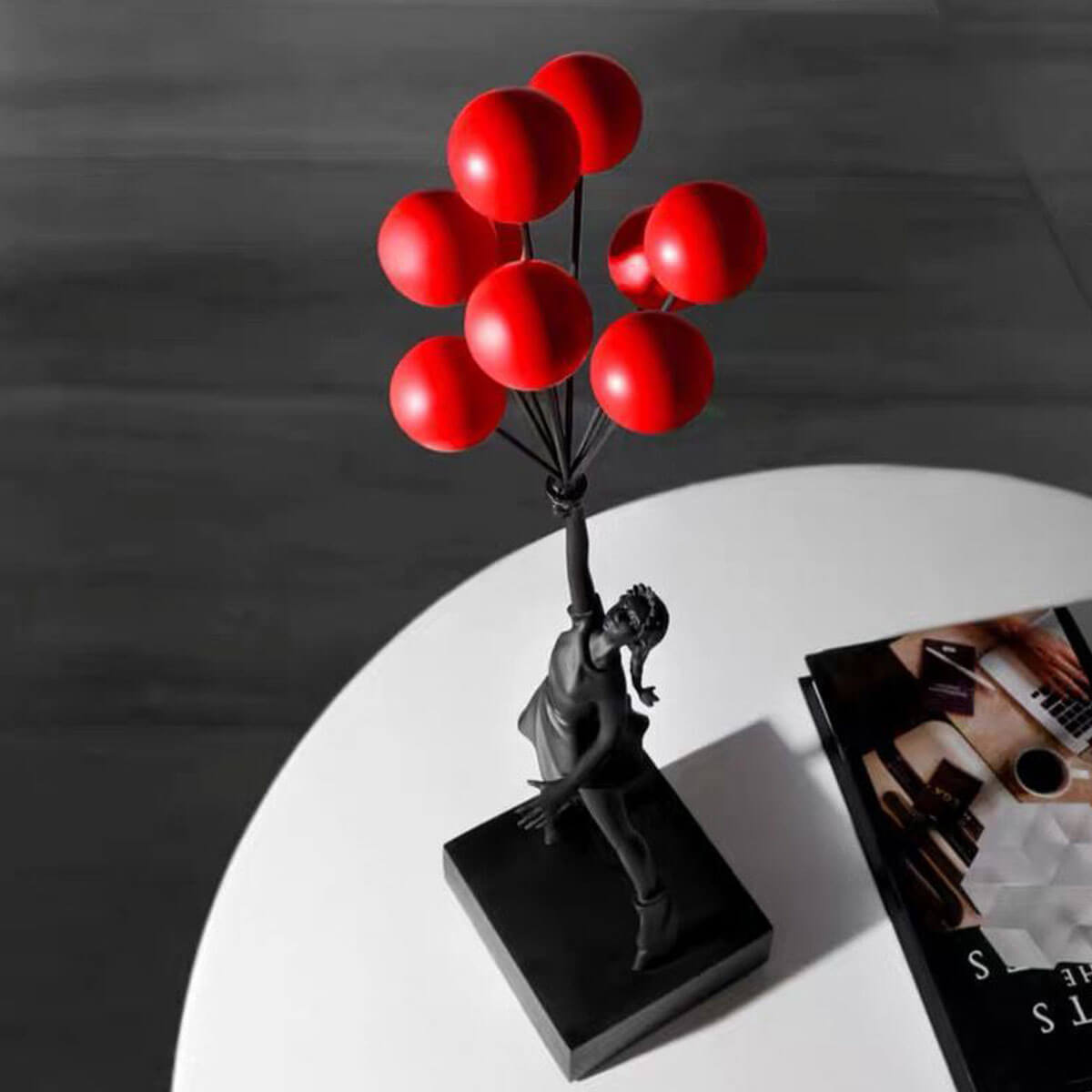 Black Flying Balloon Girl Banksy Statue with red balloons on monochrome background, contemporary art sculpture